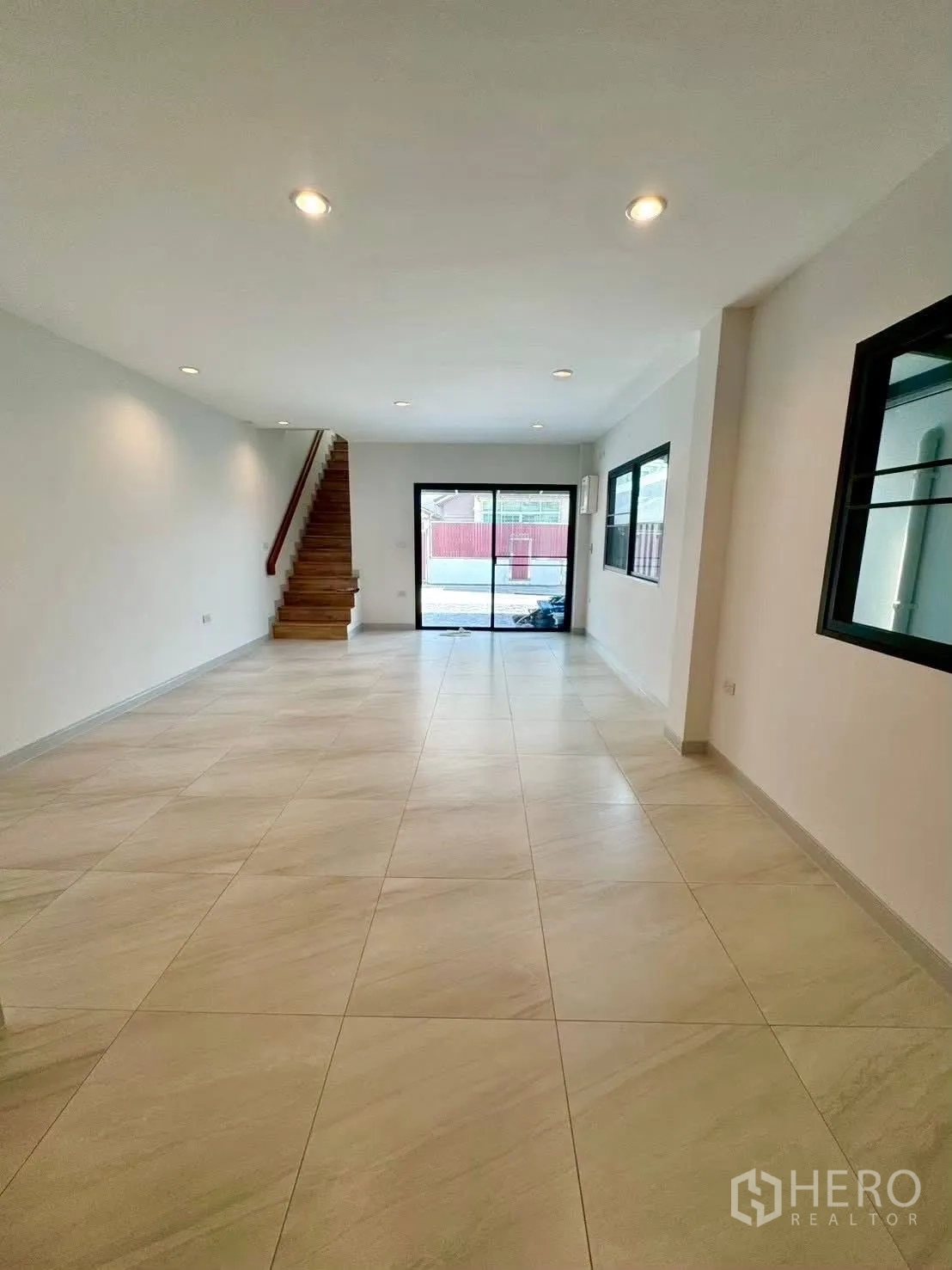 Home Office for rent in Wang Thonglang, Bangkok - Ground-floor hall with recessed lights, stairs, and rear sliding doors.