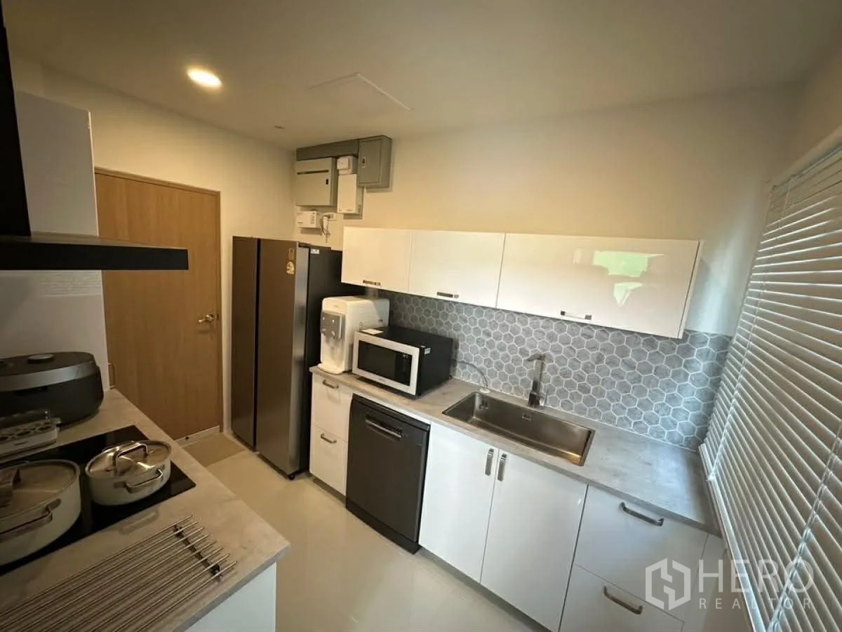 บ้านเดี่ยว for rent in Bang Phli, Samut Prakan - ครัวปิดสไตล์โมเดิร์น ตู้สีขาว ตู้เย็น ไมโครเวฟ และผนังลายหกเหลี่ยม