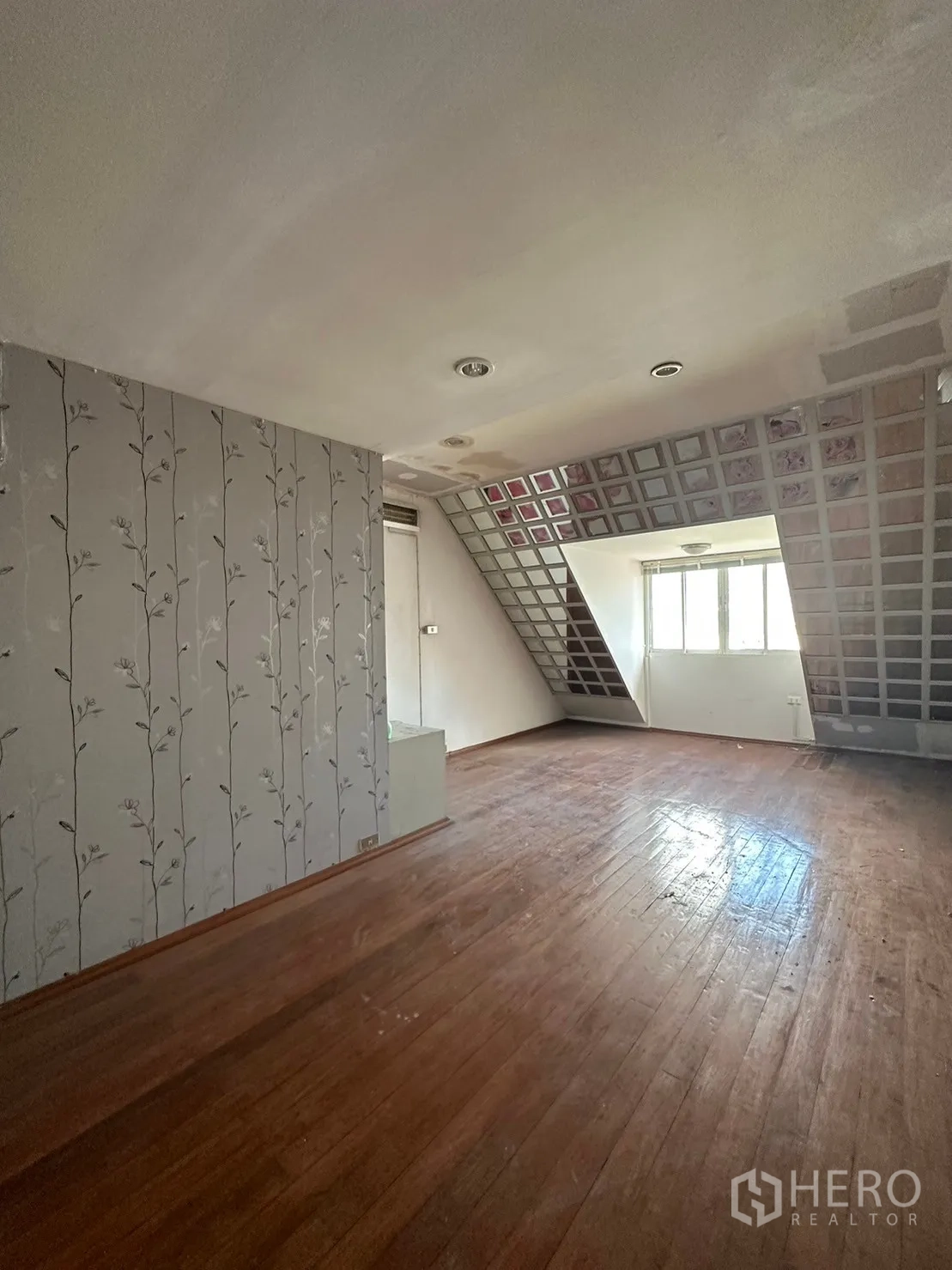 พื้นที่ขายปลีก ให้เช่าในWatthana, Bangkok - ห้องกว้างพื้นไม้ ผนังวอลเปเปอร์ลายดอก และเพดานลาดเอียง