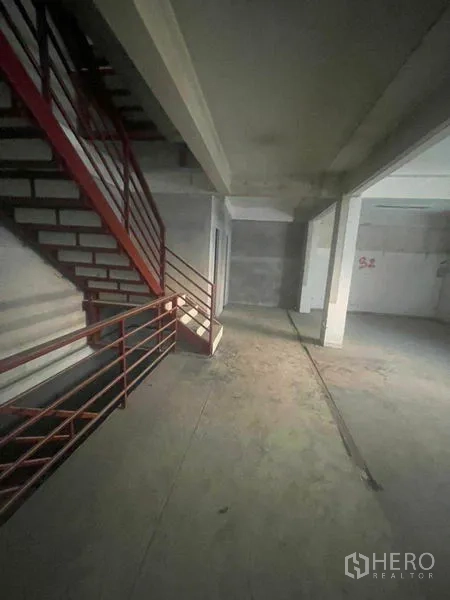 店屋 出租在Watthana, Bangkok - 室内红色金属楼梯与未完成的混凝土墙面。