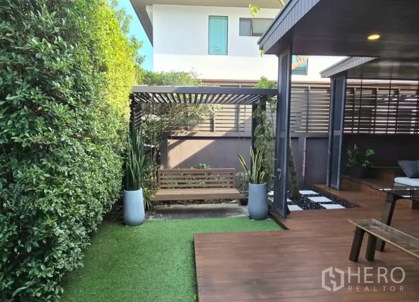 独立式住宅 出租在Bang Phli, Samut Prakan - 花园凉棚与秋千椅，被高绿篱围合