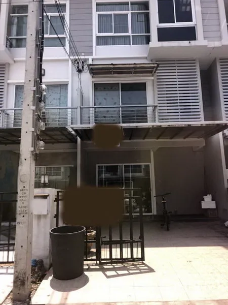 Townhouse for sale in Suan Luang, Bangkok - Three-storey modern townhouse exterior in Prawet, Bangkok with gated carport, metal awning, balcony and sliding glass doors.