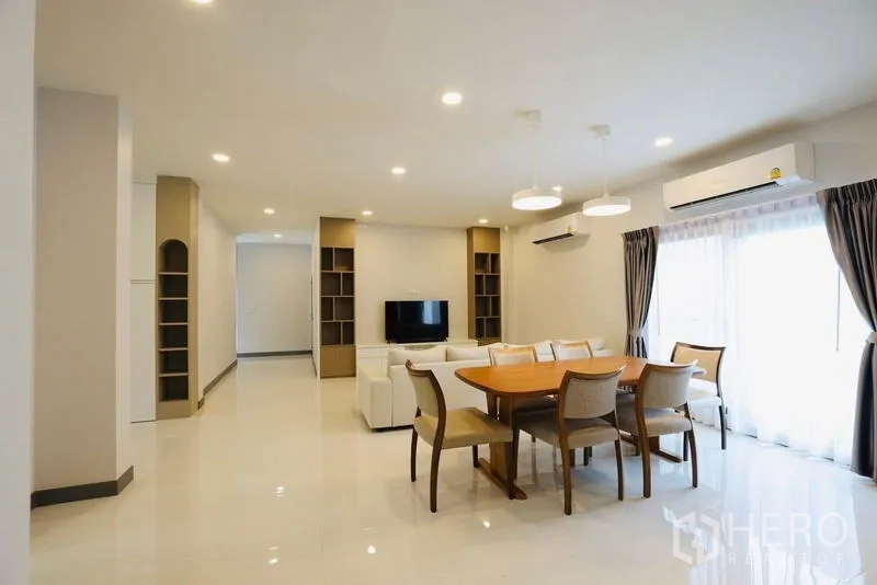 Detached House for rent in Bang Phli, Samut Prakan - Bright open-plan living and dining area with sofa, TV, and a six-seat wooden table.