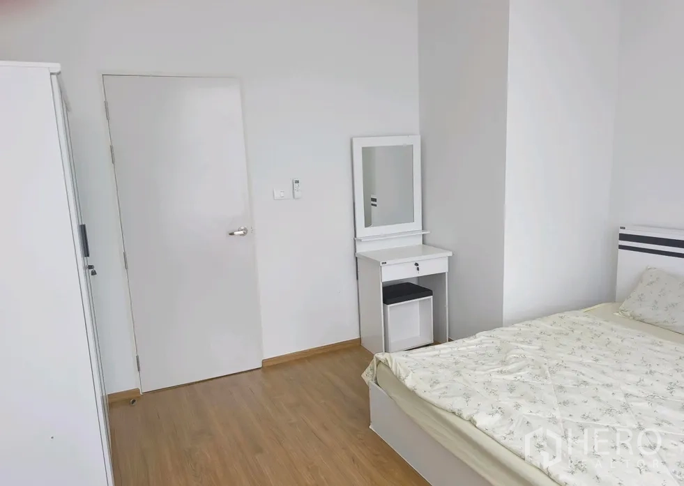 Townhouse for rent in Bang Phli, Samut Prakan - Bright bedroom with white vanity, bed and wooden floors.