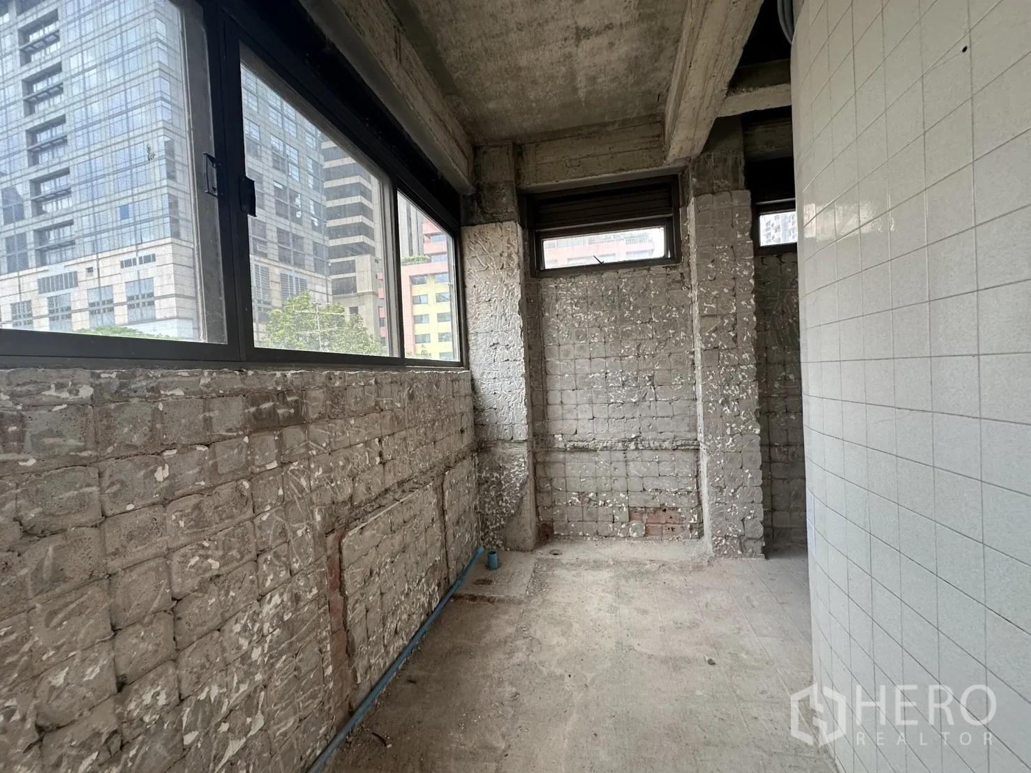 พื้นที่ขายปลีก ให้เช่าในBang Rak, Bangkok - โถงบริการผนังก่ออิฐโชว์แนวพร้อมหน้าต่างมองเห็นอาคารสำนักงาน