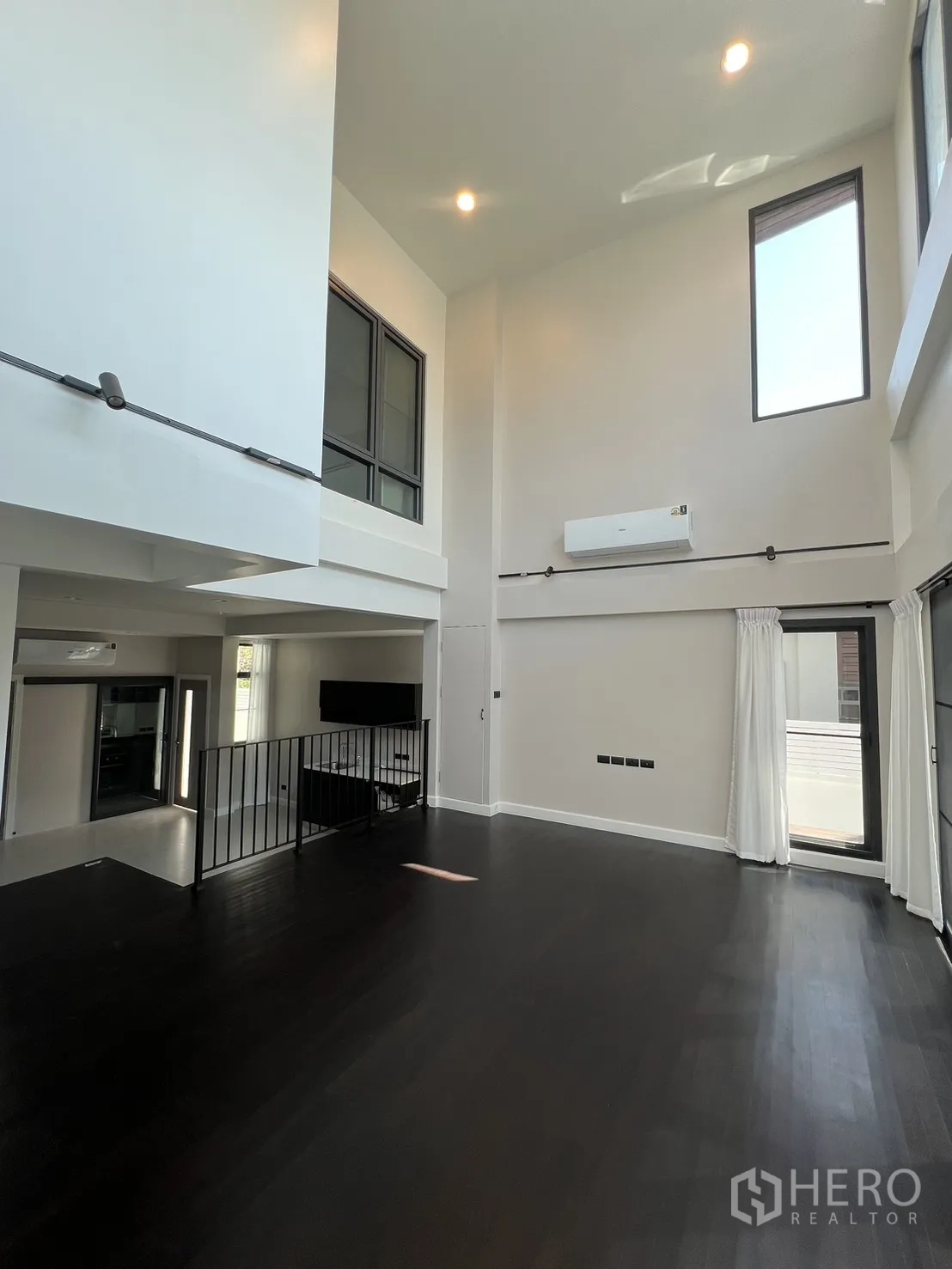 บ้าน ให้เช่าในSaphan Sung, Bangkok - ห้องเพดานสูง หน้าต่างทรงสูง ผนังสีขาว และพื้นไม้เข้ม