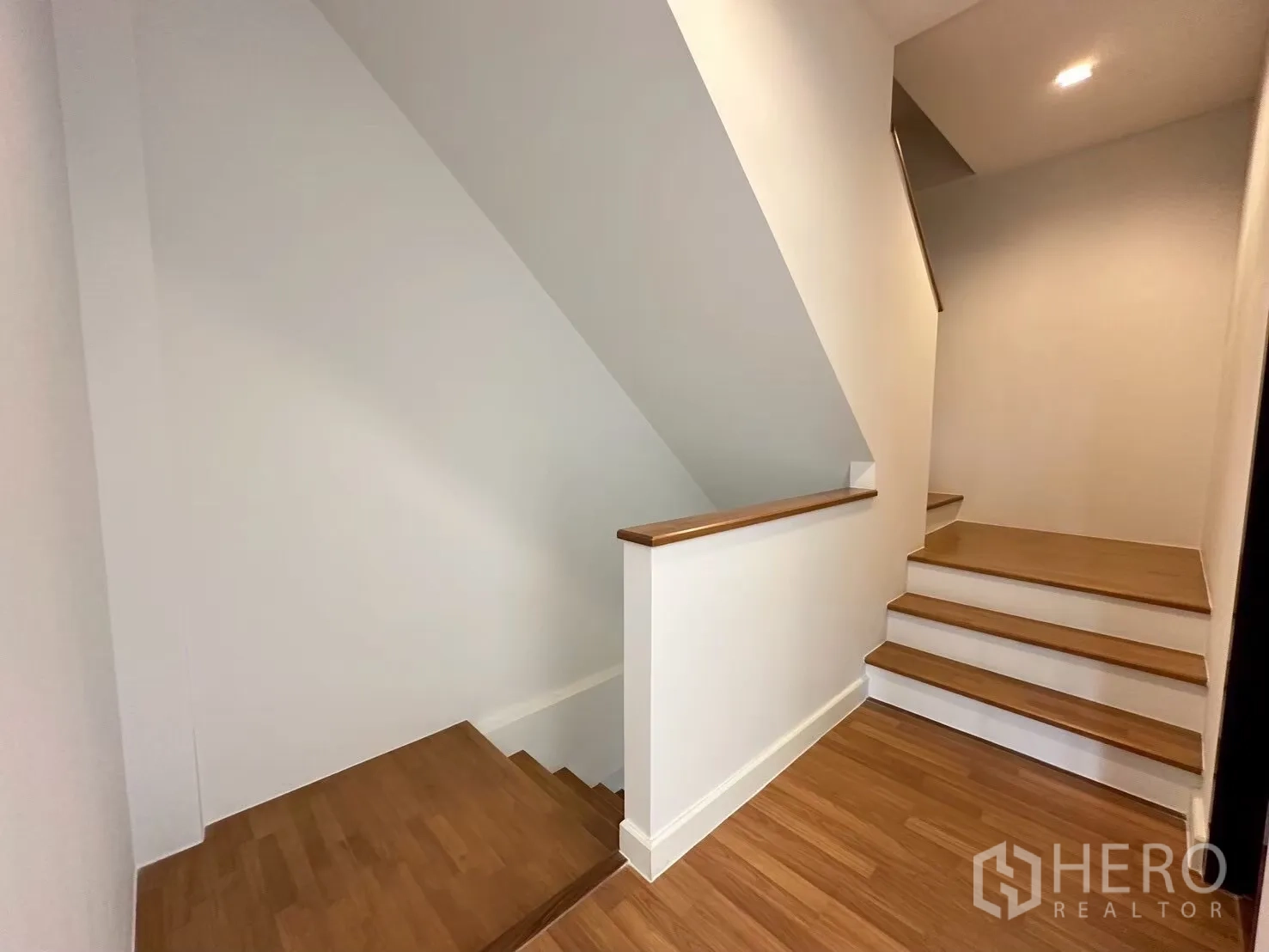 สำนักงานที่บ้าน for rent in Lat Phrao, Bangkok - บันไดไม้และโถงพักบันได ผนังสีขาวพร้อมไฟดาวน์ไลท์.