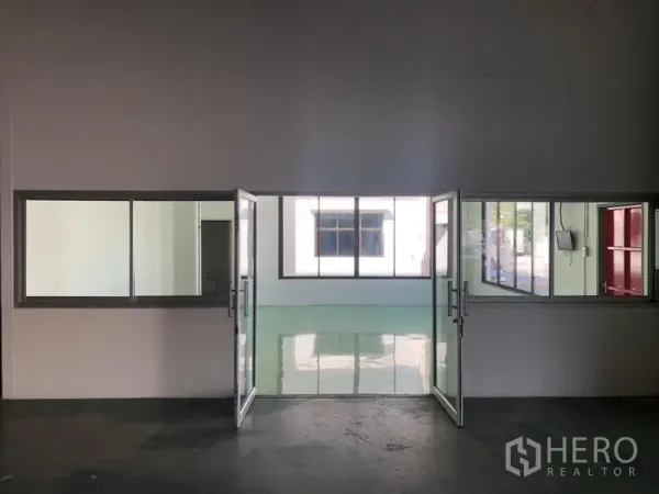 货栈 出租 - 双扇玻璃门通向明亮办公室，镜面环氧地坪。