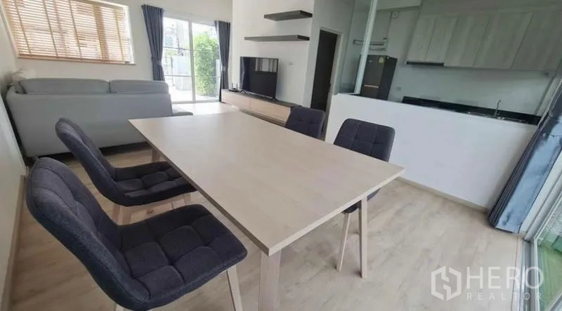 ทาวน์เฮาส์ ให้เช่าในPrawet, Bangkok - มุมทานอาหารโต๊ะสี่ที่นั่ง ข้างผนังทีวีและฉากกระจกกั้นครัว.