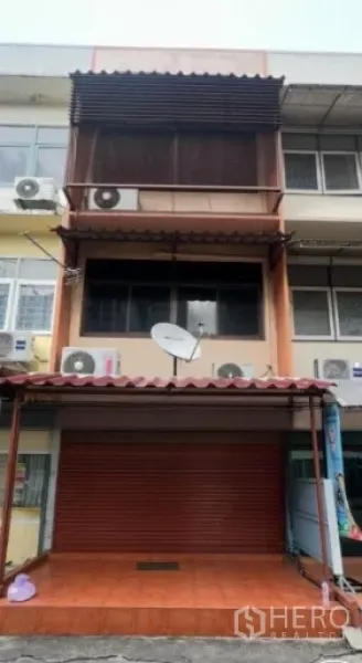零售空间 出租在Watthana, Bangkok - 三层商住式店屋外观，红色卷闸门与遮雨棚