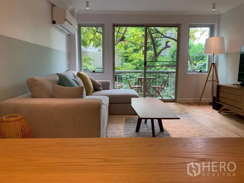 คอนโด ขายในWatthana, Bangkok - โถงนั่งเล่นเปิดโล่งหันสู่ระเบียงและวิวใบไม้เขียว