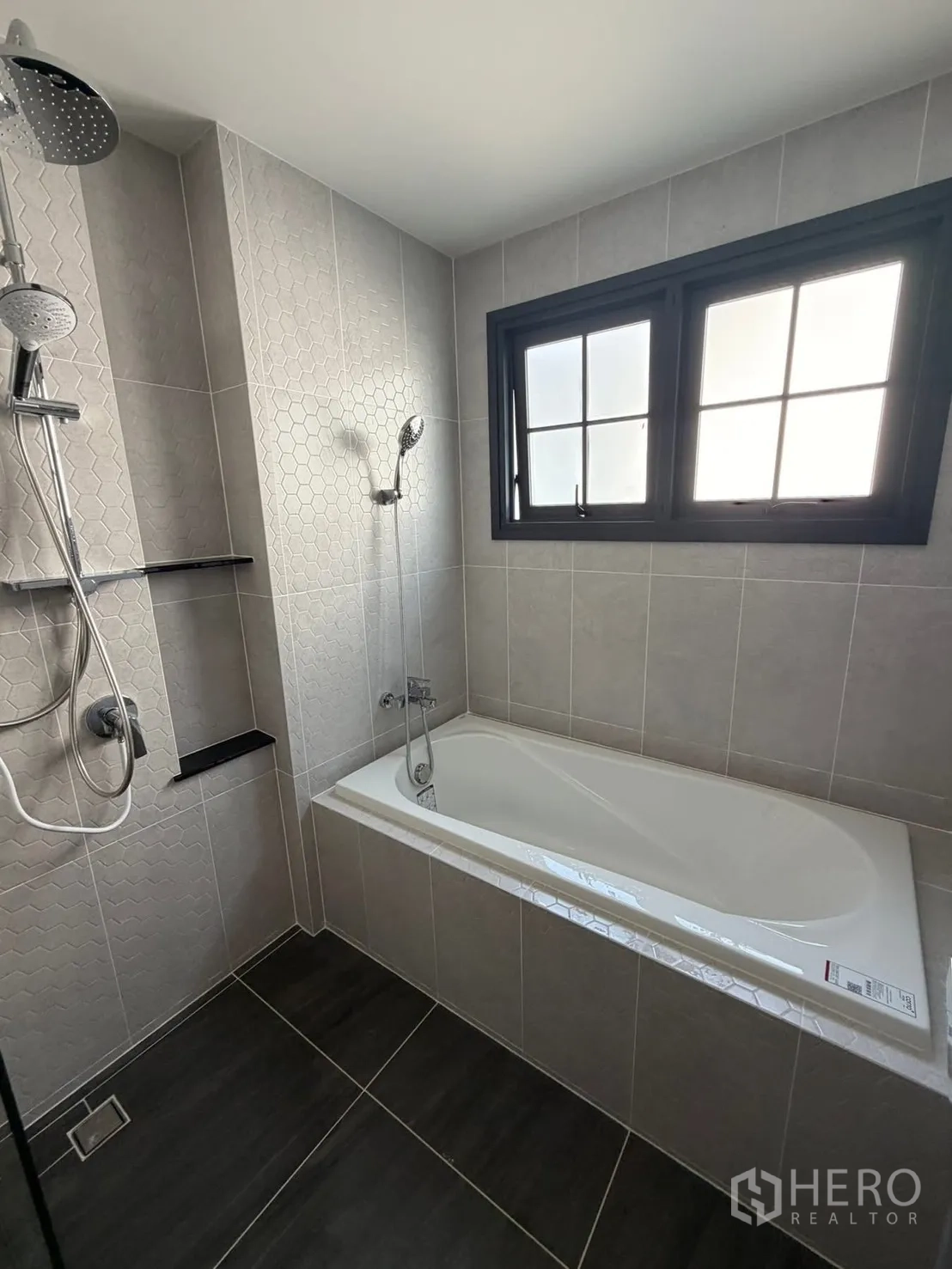 Detached House for rent in Bang Phli, Samut Prakan - Tiled bathroom with bathtub, rain shower, and a frosted window.