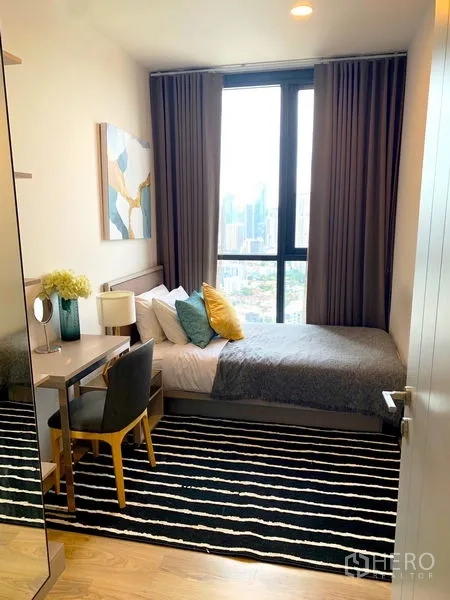 公寓 出租在Khlong Toei, Bangkok - 紧凑卧室，条纹地毯与书桌，大窗观景。