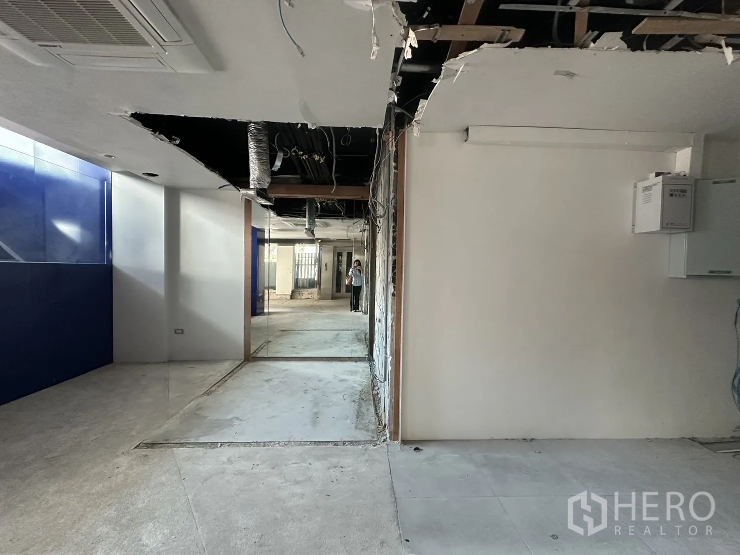 Retail Space for rent in Watthana, Bangkok - Back-of-house corridor with exposed ceiling ducts and wiring beside blue wall panels.