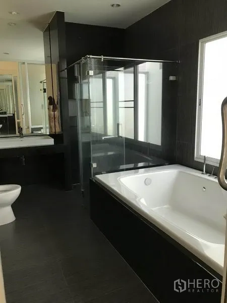 Detached House for sale in Suan Luang, Bangkok - Modern bathroom featuring a bathtub, glass shower enclosure and vanity.