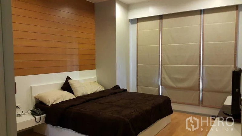 คอนโด ให้เช่าในKhlong Toei, Bangkok - ห้องนอนใหญ่กว้างพร้อมผนังลายไม้ ม่านบังแสง และเตียงคิงไซซ์