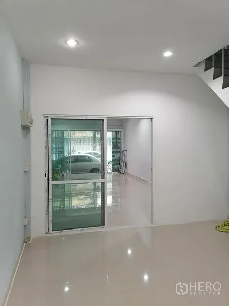 Shophouse for rent in Bang Rak, Bangkok - Interior area with sliding glass door, staircase access and reflective tiles suited for office setup.
