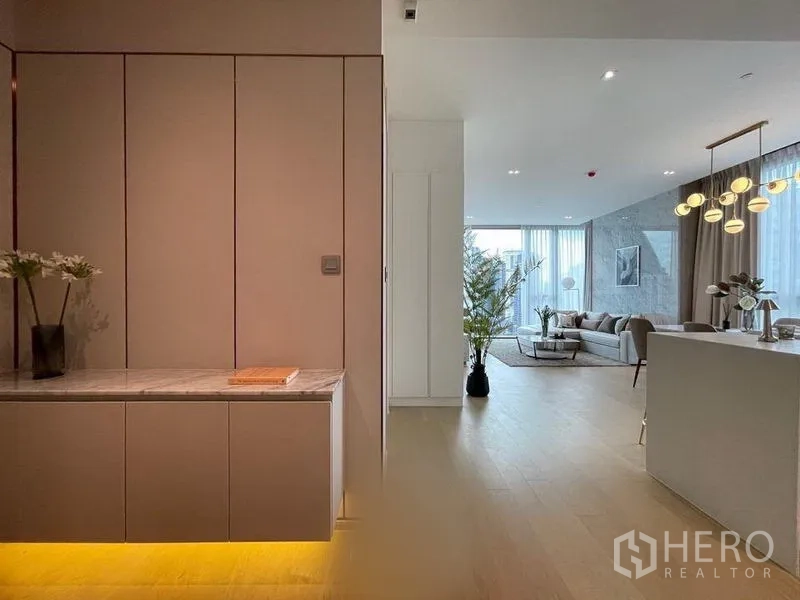 公寓 出租在Watthana, Bangkok - 入口走廊设嵌入式柜体与暖色灯光，通向开放式客餐厅。