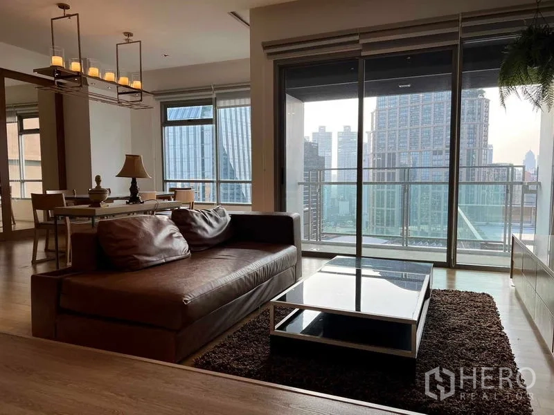 คอนโด ให้เช่าในWatthana, Bangkok - ห้องนั่งเล่นพร้อมโซฟาหนัง โต๊ะกลาง และระเบียงชมวิวสกายไลน์