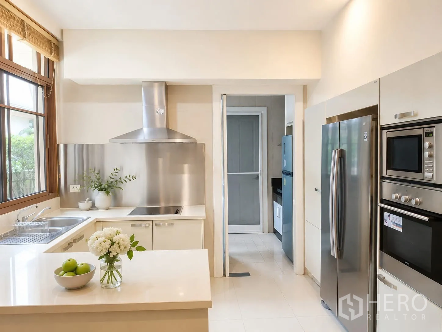 Detached House for rent in Watthana, Bangkok - Modern kitchen with island, stainless appliances and range hood.