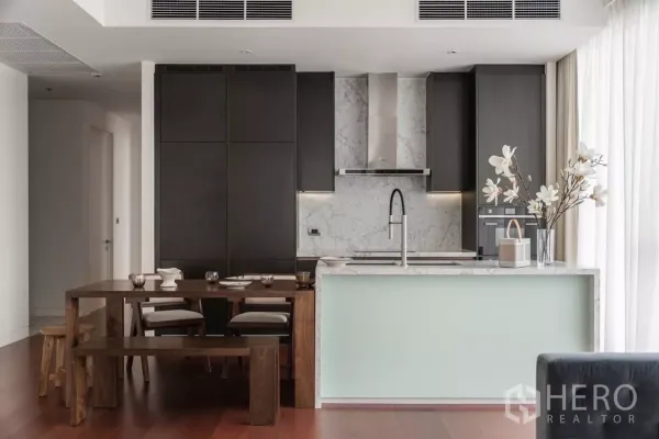 คอนโด ให้เช่าในWatthana, Bangkok - ครัวโมเดิร์น ผนังหินอ่อน ตู้บิลท์อินสีเข้ม และชุดโต๊ะรับประทานอาหารไม้