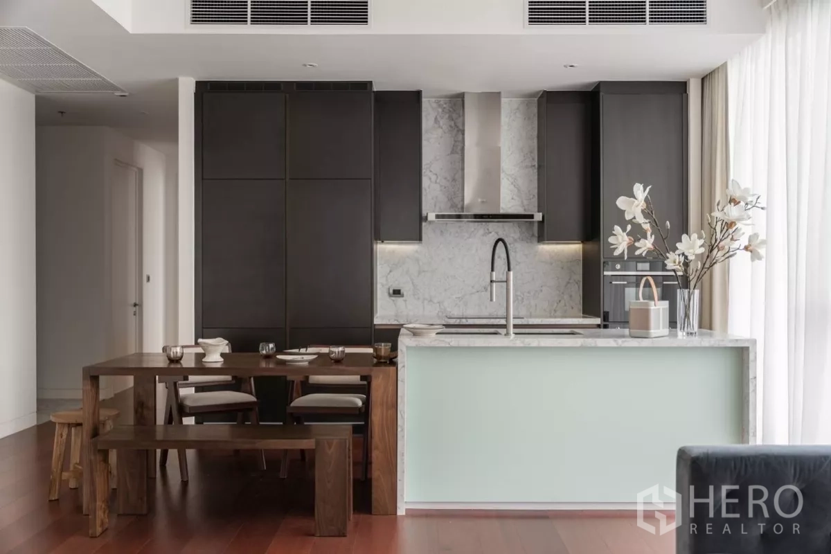 คอนโด ให้เช่าในWatthana, Bangkok - ครัวโมเดิร์น ผนังหินอ่อน ตู้บิลท์อินสีเข้ม และชุดโต๊ะรับประทานอาหารไม้