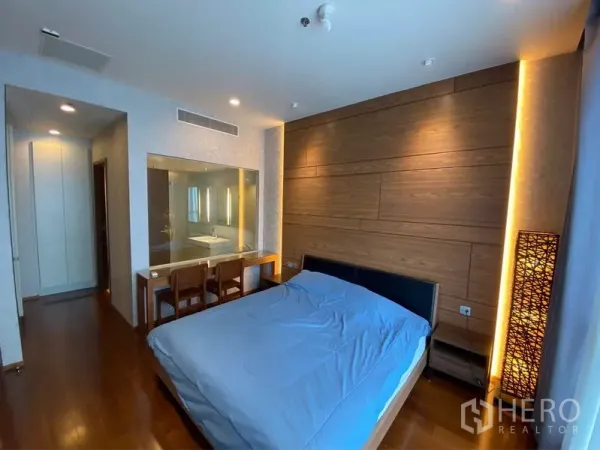 公寓 出租或出售在Watthana, Bangkok - 卧室带木质背景墙、工作梳妆台，并有观景玻璃连接套内卫浴。