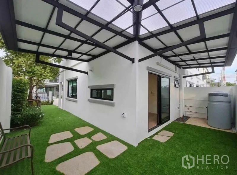 ทาวน์เฮาส์ ให้เช่าในBang Phli, Samut Prakan - ลานสวนข้างบ้านมีหลังคา ปูหญ้าเทียม แผ่นทางเดิน ประตูกระจกเลื่อน ถังเก็บน้ำ