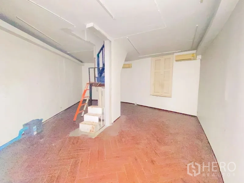 店屋 出租在Phra Nakhon, Bangkok - 上层大开间，鱼骨纹地面、窗户与楼梯核心。