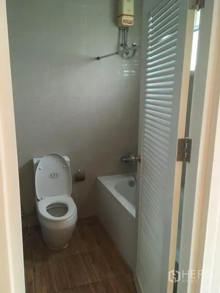 Townhouse for rent in Din Daeng, Bangkok - Guest bathroom with toilet, bathtub and water heater.