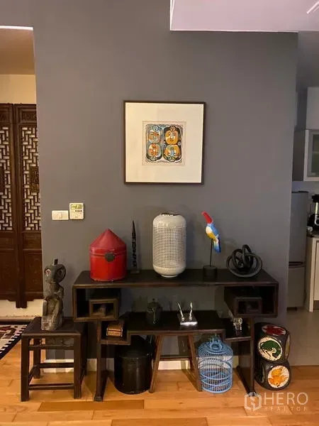 คอนโด ให้เช่าในKhlong Toei, Bangkok - คอนโซลตกแต่งชิดผนังสีเทา พร้อมกรอบรูปและของสะสมในคอนโด