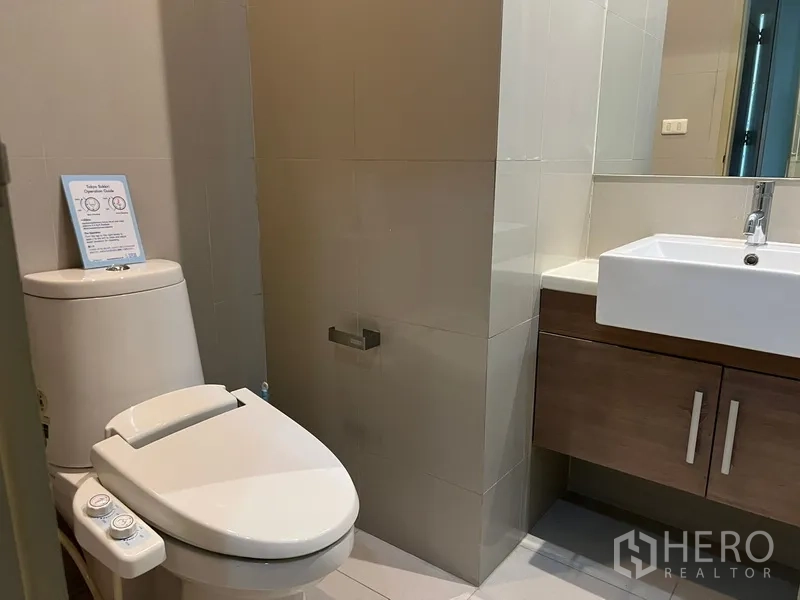 Condominium for rent or sale in Watthana, Bangkok - Modern bathroom with toilet, vanity and neutral tiles