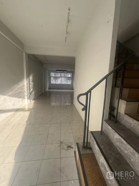 อาคารพาณิชย์ ให้เช่าในKhlong Toei, Bangkok - โถงทางเดินพร้อมบันไดขึ้นชั้นบนและพื้นที่ร้านด้านหน้า.