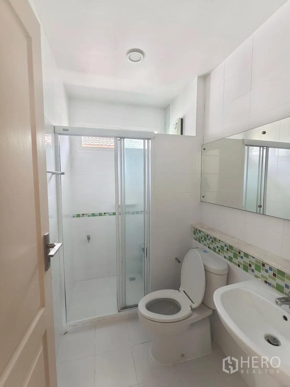 Detached House for rent in Bang Kapi, Bangkok - Bright white bathroom with glass shower enclosure.