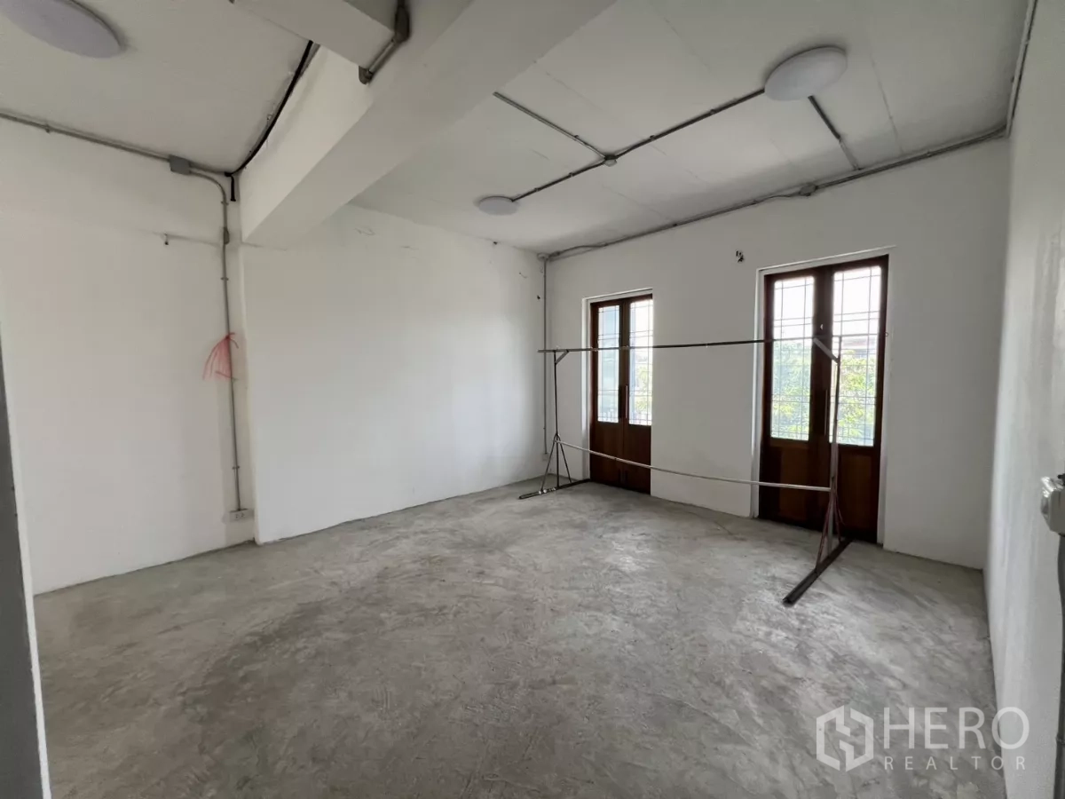 零售空间 出租在Khlong Toei, Bangkok - 宽敞白色房间，双木质法式窗，外露管线天花。