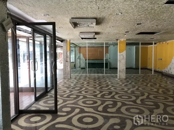 零售空间 出租在Khlong Toei, Bangkok - 宽敞展厅区，带玻璃隔断与结构立柱。