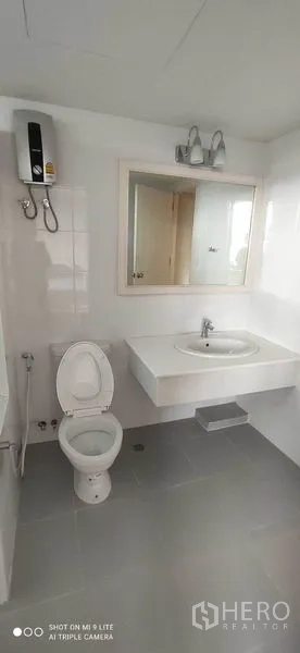 คอนโด ให้เช่าในWatthana, Bangkok - ห้องน้ำโทนขาวสว่าง พร้อมโถสุขภัณฑ์ อ่างล้างหน้า กระจก และเครื่องทำน้ำอุ่น