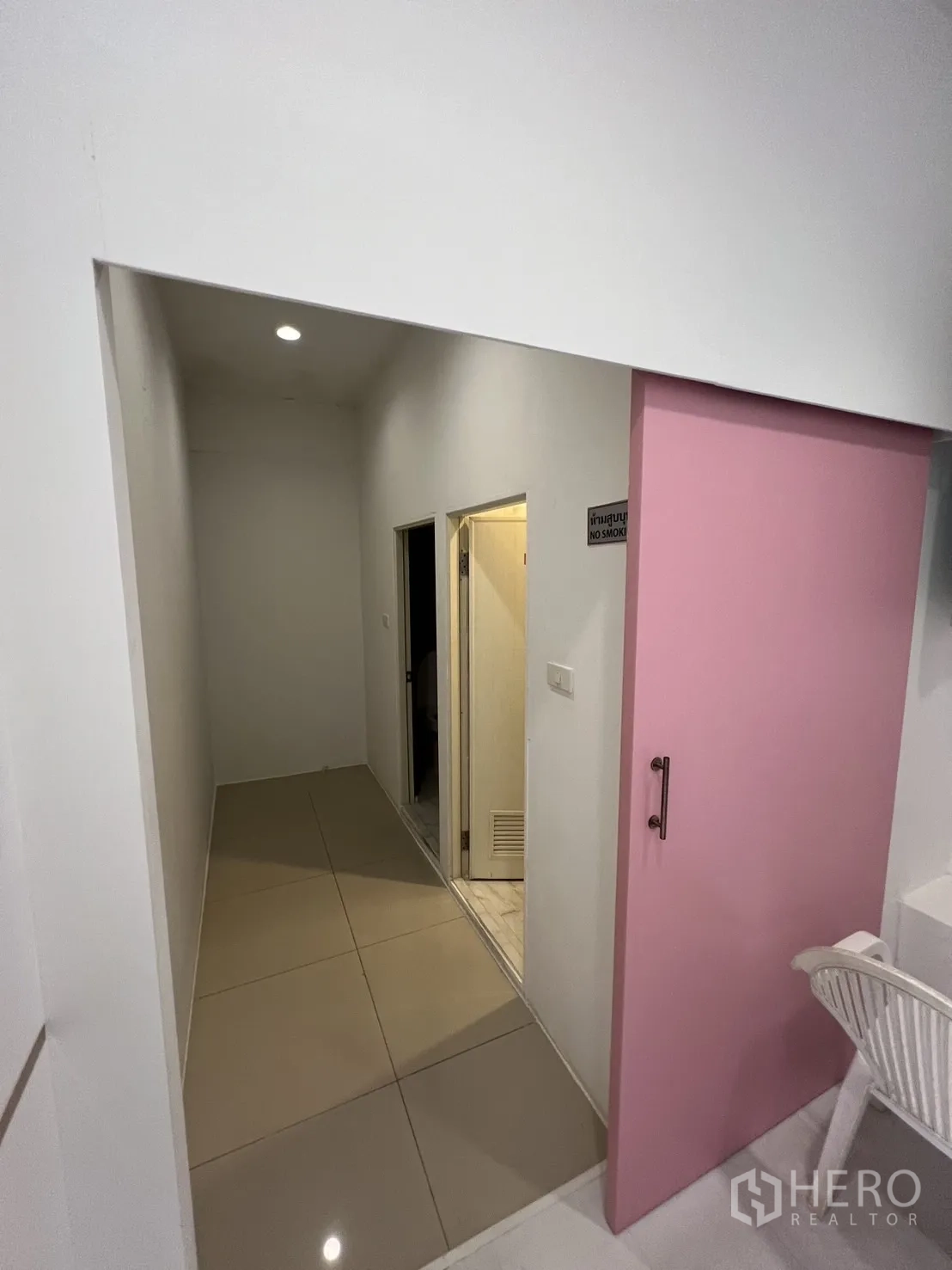 零售空间 出租在Watthana, Bangkok - 走廊与粉色推拉门，通向储物与设备间。