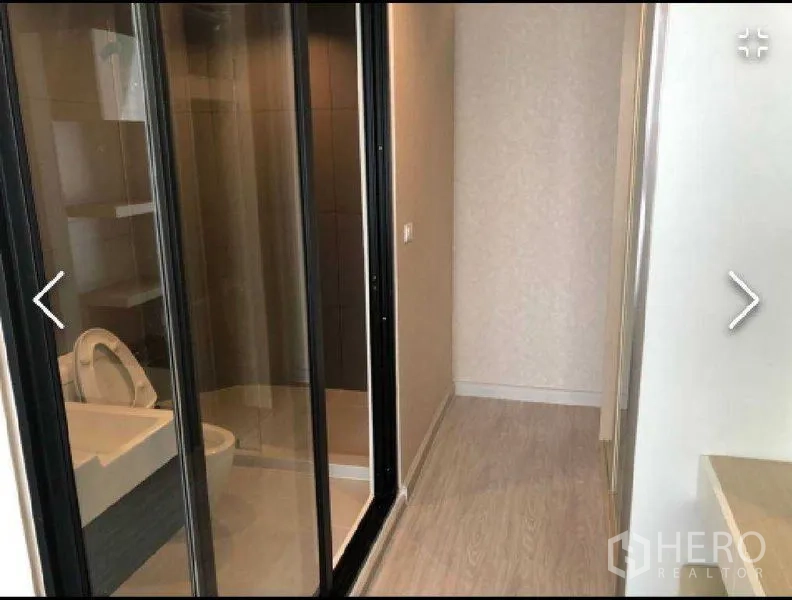 公寓 出租在Watthana, Bangkok - 现代浴室，玻璃推拉门与淋浴间，旁接木地板走廊