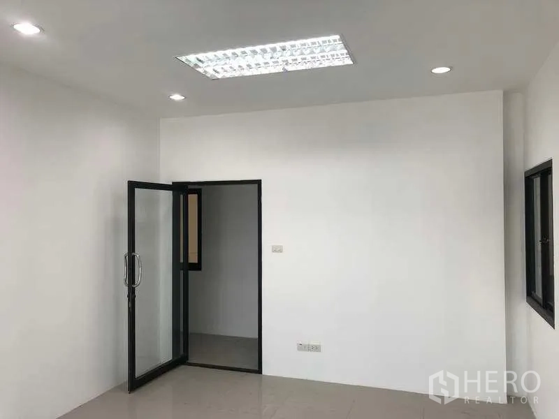 Factory for rent or sale in Bang Phli, Samut Prakan - Bright office room with glass door, white walls, recessed lighting and tiled floor.