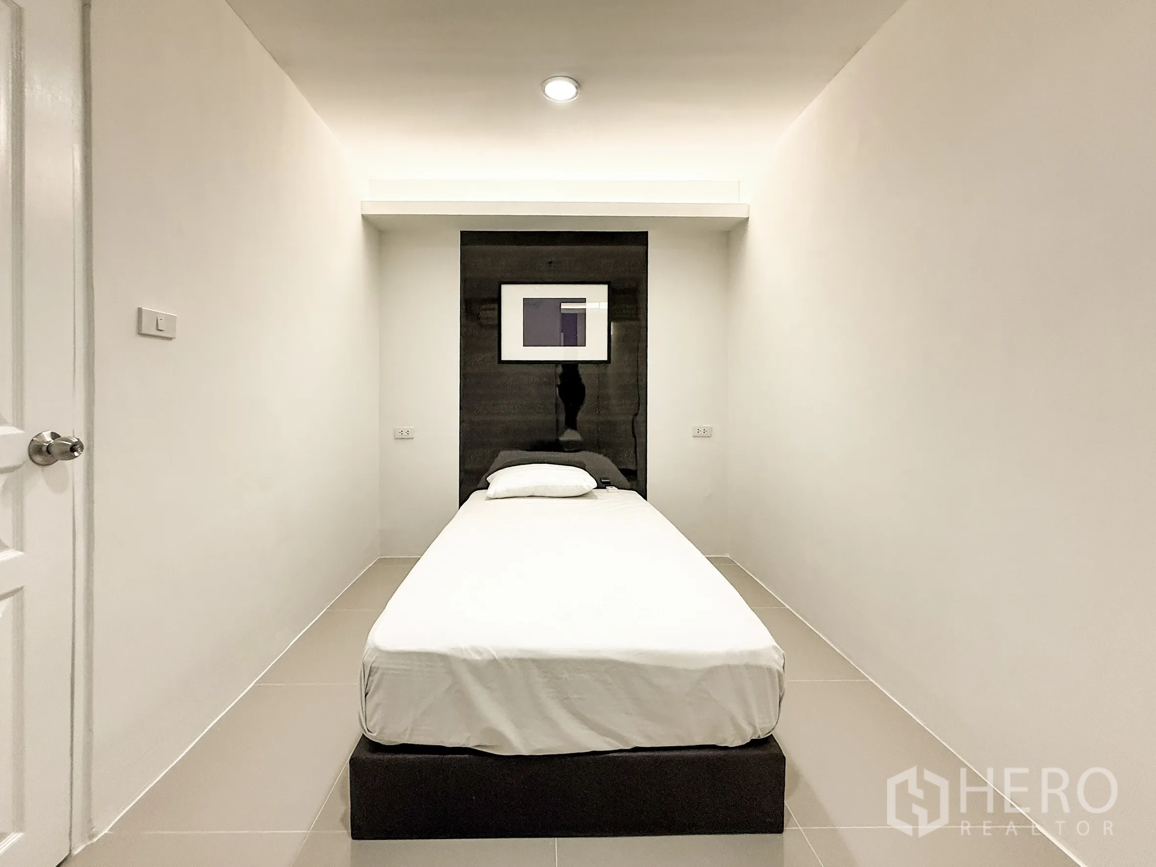 公寓 出租在Khlong Toei, Bangkok - 紧凑的女佣房，单人床与特色墙面。