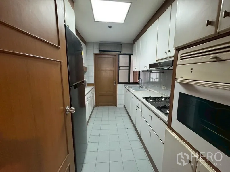 คอนโด ให้เช่าในWatthana, Bangkok - ครัวทางเดินยาว ตู้สีขาว เตาแก๊ส เตาอบ และตู้เย็นขนาดใหญ่