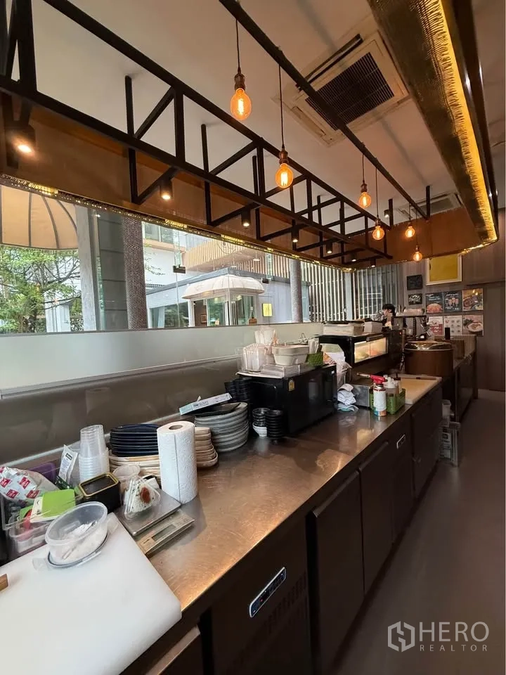 Retail Space for rent in Watthana, Bangkok - Long stainless service counter under pendant lights with storage below.