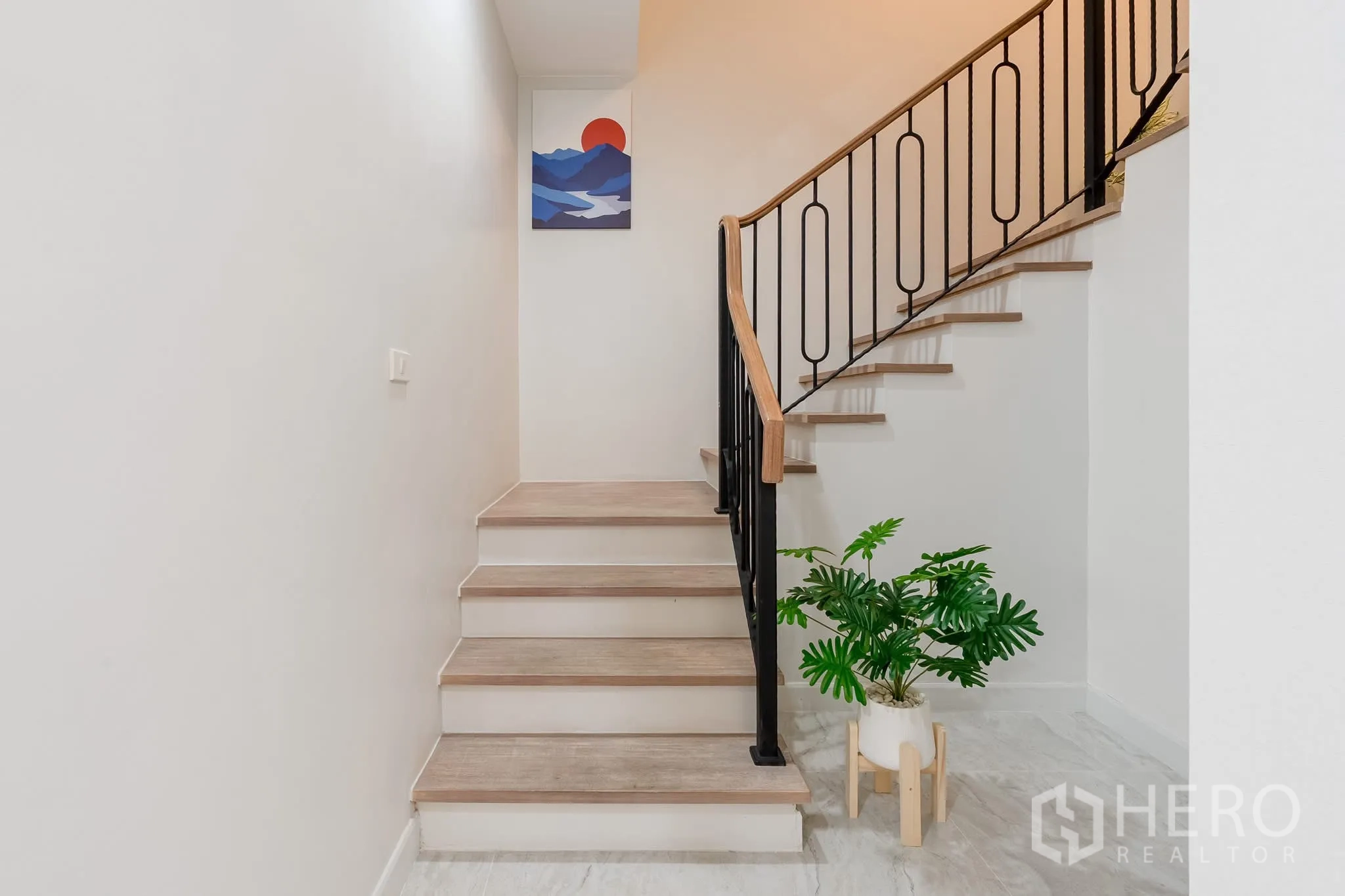 家庭办公室 for rent in Khlong Toei, Bangkok - 楼梯下层平台，摆放盆栽与铁艺栏杆。