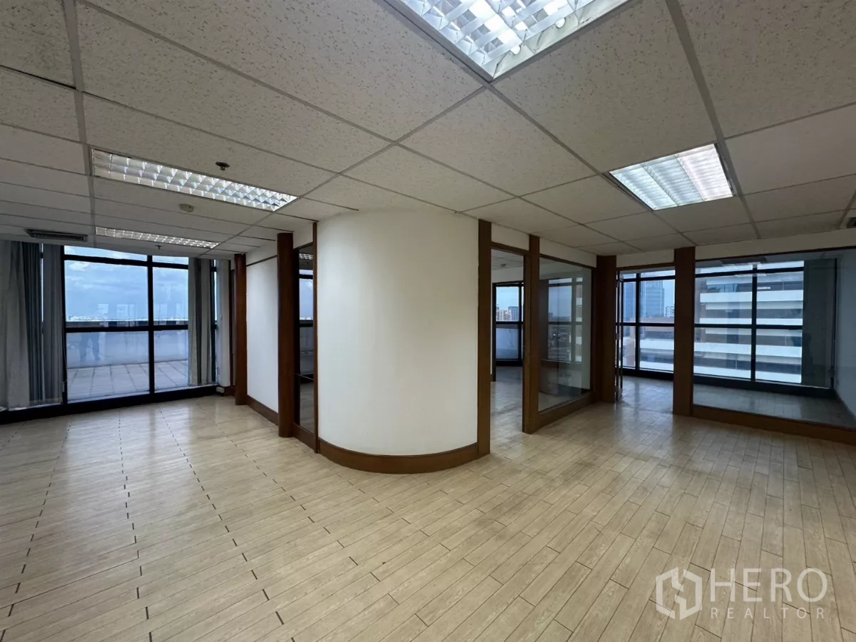 Office Space for rent in Watthana, Bangkok - Corner workspace with curved wall, glass doors and access to a large terrace outside.