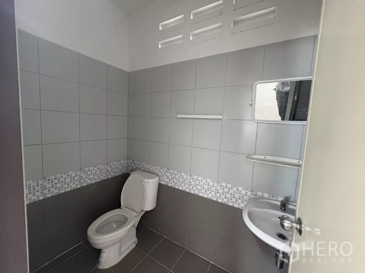 工厂 出租在Phra Samut Chedi, Samut Prakan - 整洁的瓷砖卫生间，带马桶、洗手盆和通风砖。