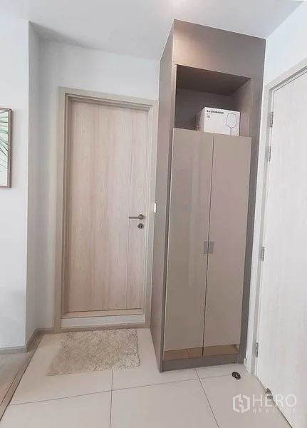 Condominium for rent in Pathum Wan, Bangkok - Entry hallway with built-in cabinet and light wood doors.