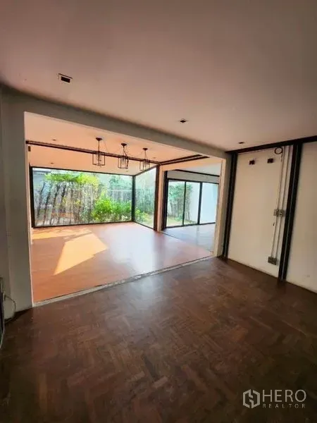 带办公室的家 出租在Lat Phrao, Bangkok - 开放式工作室，吊灯与落地推拉玻璃，连接花园露台。