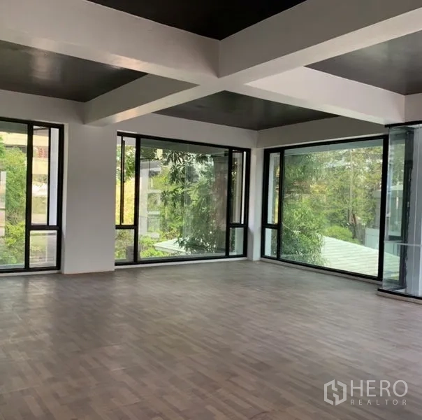 独立商业地产 出租在Khlong Toei, Bangkok - 转角楼层配全景窗与木地板，适合办公室、展厅或工作室。