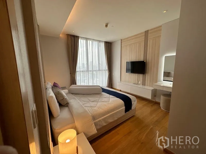 公寓 出租在Watthana, Bangkok - 卧室设特大床、大窗、悬空电视柜与浅色木饰面。